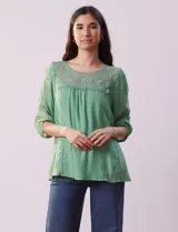 Blusa verde agua de gasa con cuello redondo y aplique de crochet. Tiene mangas 3/4 amplias con puño y botón, y forro interno a tono.