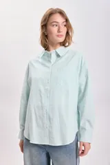Camisa de manga larga con cuello clásico, corte recto y cierre frontal con botones. Diseño a rayas verticales finas en color verde agua y blanco.