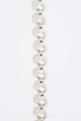 Collar de perlas blancas con detalle de labios rojos y logotipo grabado. Cierre con mosquetón metálico.