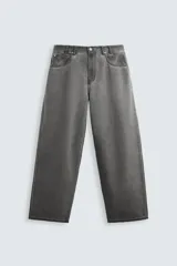 Pantalón de jean gris de corte amplio, estilo balloon fit, con cinco bolsillos, cierre frontal con cremallera y botón, y efecto de color lavado en toda la prenda.