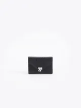 Billetera negra de cuero vacuno con textura graneada, cierre de solapa con imán y aplique metálico en forma de llama. En el interior, cuenta con múltiples compartimentos para tarjetas y un bolsillo con cierre metálico.