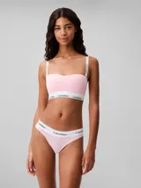 Conjunto de ropa interior Calvin Klein, compuesto por un corpiño bandeau y una bombacha colaless, ambos en color rosa claro con banda elástica blanca con el logo de la marca.