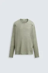 Jersey color verde claro de punto tejido en hilatura ligera de lino, corte relaxed fit, cuello redondo y manga larga con terminaciones en rib.