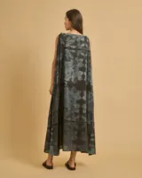 Vestido largo sin tirantes con estampado floral en tonos grises sobre fondo negro.