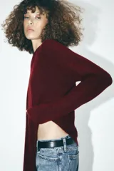 Sweater de punto color borgoña, de corte recto, cuello redondo y manga larga.
