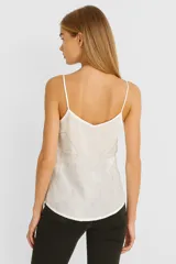 Musculosa negra de breteles finos con escote en V y bordado blanco con motivos geométricos.