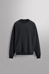 Sudadera negra de entrenamiento relaxed fit confeccionada en tejido de algodón con interior rizo, cuello redondo, manga larga y acabados en rib.