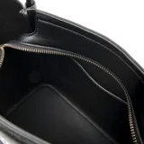 Bolso tote negro de cuero sintético con asas fijas y correa desmontable regulable. Tiene acceso con cierre, herrajes dorados y un bolsillo interno con cierre.