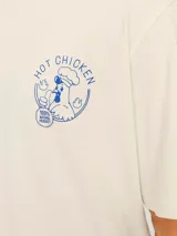 Camiseta color crema de manga corta y cuello redondo con estampado azul de un pollo con la frase "Hot Chicken" y el logo de la marca.