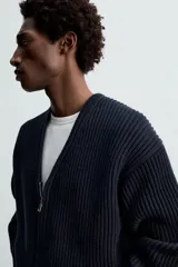 Cárdigan azul marino de punto con cremallera frontal, cuello en pico y manga larga.