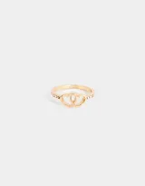 Anillo dorado con dos corazones entrelazados y pequeños brillantes a los lados.