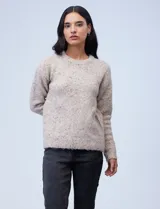 Buzo de tejido melange color beige con puntos oscuros, cuello redondo y manga larga.