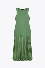 Vestido largo verde con escote redondo y sisas amplias. La parte superior es de punto liso y la falda es plisada de tejido satinado.