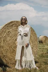 Pollera larga color crudo tejida a mano en crochet, con doble capa de flecos.