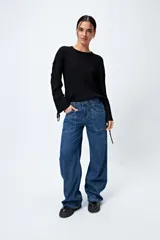 Pantalón de jean gris oscuro, tiro bajo, corte baggy y doble bolsillo.