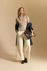 Pantalón ancho de tiro alto, color negro, con costuras contrastantes en blanco que definen los bolsillos y los bordes.