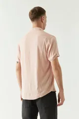 Camisa color rosa claro, de manga corta con dobladillo y cuello clásico. Corte slim fit.