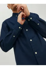Camisa de manga larga de algodón tipo oxford, color azul marino, con cuello botón y cierre frontal de botones.