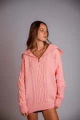 Buzo de punto color rosado, con cuello polo y cierre frontal parcial, de manga larga y diseño holgado.