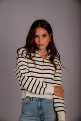 Sweater de punto color beige con rayas horizontales blancas, cuello polo con cierre de cremallera y mangas largas.
