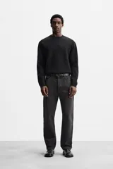 Sweater negro de punto con cuello redondo y mangas largas.