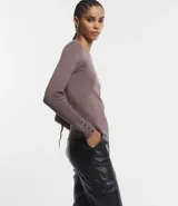 Suéter de punto color verde, con cuello barco, mangas largas y textura acanalada.