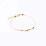 Pulsera con cuentas transparentes y detalles en dorado, de diseño delicado.