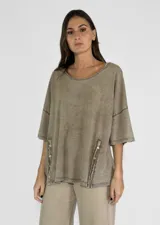 Remera color amarillo con cuello redondo y mangas cortas amplias, con detalle de botones en los laterales.