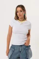 Remera blanca de morley suave y elastizado, con calce al cuerpo y cuello redondo. Tiene un pez bordado en el frente.