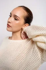 Buzo negro de acrílico con tejido calado y mangas largas.