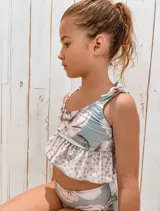 Conjunto de bikini para niña con estampado floral en la parte inferior y animal print en la parte superior. El top tiene tirantes con lazos y volantes en la parte inferior.