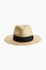 Sombrero de paja trenzada color beige con cinta de grosgrain negra.