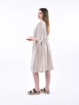 Vestido corto color gris claro, con escote en V, mangas cortas amplias y lazo ajustable en la cintura.