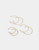 Set de tres pares de aros tipo argolla de metal dorado, en diferentes tamaños, con cierre de tope a presión.