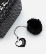 Bolso transversal tipo camera bag, color negro, hecho en material sintético texturizado. Tiene correa fina ajustable y removible, cierre por cremallera y colgante pompón.