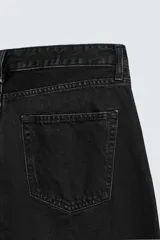 Pantalón de jean celeste de corte flare, con tiro medio, cinco bolsillos, cierre frontal con cremallera y botón, y bajo con acabado irregular.