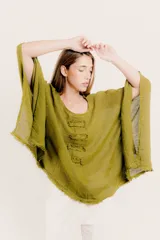 Blusa color ladrillo de lino con cuello redondo y mangas largas amplias. Presenta detalle de apliques rectangulares verticales en el frente.