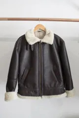 Campera gamulán marrón oscuro con cuello, cierre y puños de piel sintética color crema.