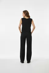 Musculosa de algodón color lila, corte holgado y sin mangas, con cuello redondo a la base. Presenta un estampado frontal de flores estilizadas en amarillo y azul con texto.