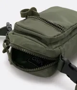 Bolso mini bandolera color blanco con correa ajustable, cierre de cremallera y bolsillo frontal con cremallera.