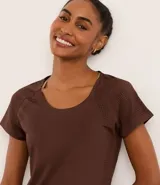 Remera deportiva marrón de microfibra, con cuello redondo, mangas cortas con laterales perforados y calce ajustado.