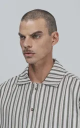 Camisa de corte clásico en tela de rayas blanca y verde, con botones frontales y mangas cortas.