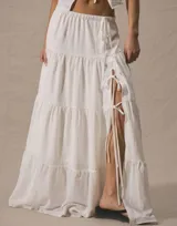 Pollera larga blanca de tiro alto, con volados en capas y abertura lateral ajustable con cordones.