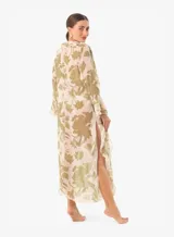 Vestido playero largo con estampado floral en tonos verdes y blancos, con volados de encaje en escote, mangas y ruedo. Mangas largas, abertura frontal con lazos para cerrar y aberturas laterales.