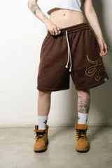 Bermuda marrón de algodón con corte oversize, cintura elástica con cordón ajustable y logo bordado en la pierna.