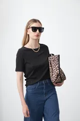 Remera negra de manga corta confeccionada en tejido acanalado elástico, con cuello redondo y calce ajustado al cuerpo.