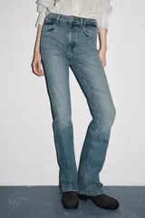 Pantalón de jean azul oscuro, de tiro bajo, corte slim fit y bootcut. Con cinco bolsillos y cierre frontal con cremallera y botón.