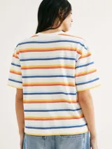 Camiseta de manga corta con cuello redondo, color blanco, con un patrón de rayas horizontales en tonos cálidos y azules (naranja, amarillo, rojo, azul oscuro y celeste).