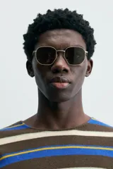 Jersey de punto tejido con lana, a rayas horizontales en tonos marrón, azul, blanco y amarillo. De corte regular, cuello redondo y manga larga.