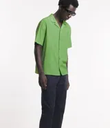 Camisa de hombre color verde claro, corte slim, de manga corta y cuello inglés. Confeccionada en viscosa texturizada.